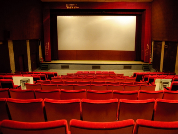 In a basically empty movie theater, a really tall person sits directly in front of you. What do you do?